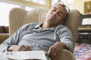 Mixed race man sleeping in armchair